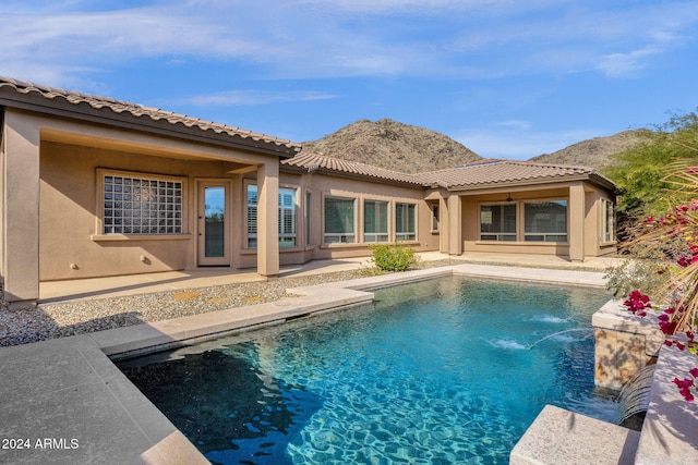 view of pool featuring ceiling fan, a patio area, and a mountain view