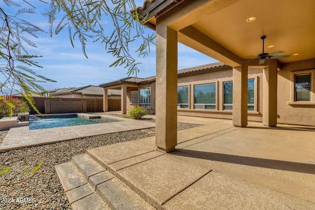 view of patio / terrace with pool water feature, a fenced in pool, and ceiling fan