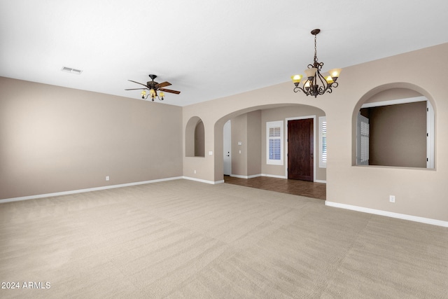 unfurnished room featuring carpet and ceiling fan with notable chandelier