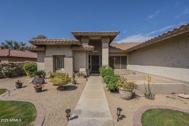entrance to property with a tiled roof and stucco siding