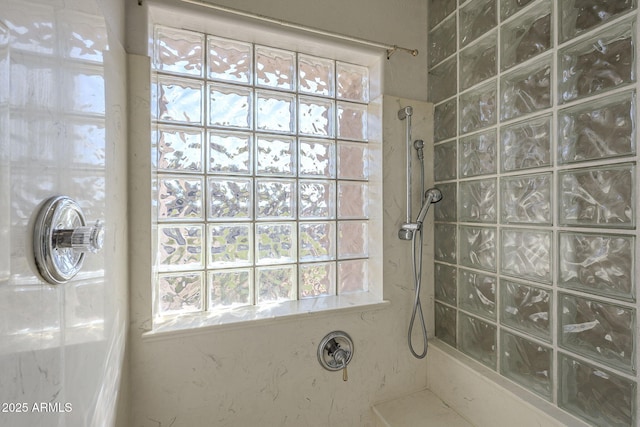 full bath with a tile shower and a healthy amount of sunlight