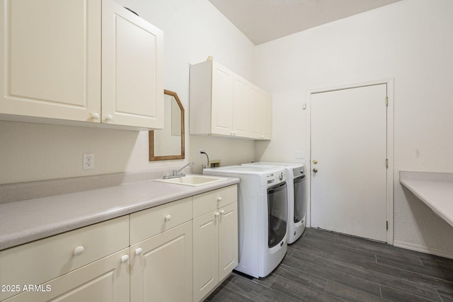 laundry room featuring washing machine and clothes dryer, cabinet space, a sink, and dark wood-type flooring