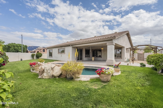 rear view of house with a fenced backyard, stucco siding, a yard, and a patio area