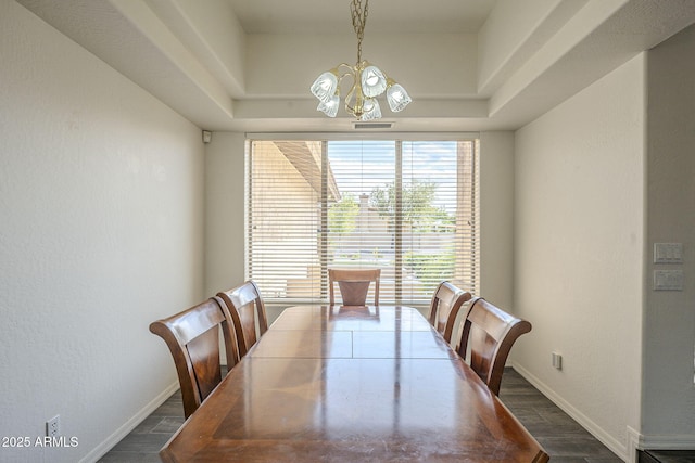 dining area with dark wood-type flooring, baseboards, and a chandelier