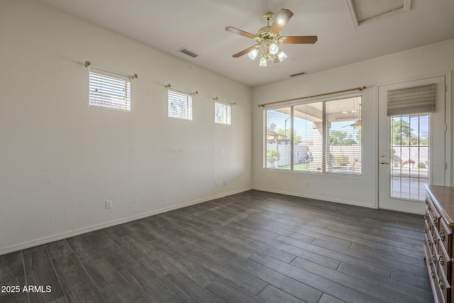 empty room with a ceiling fan, dark wood-style floors, baseboards, and visible vents
