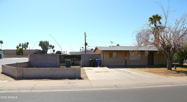 view of front of house featuring fence, a gate, and stucco siding