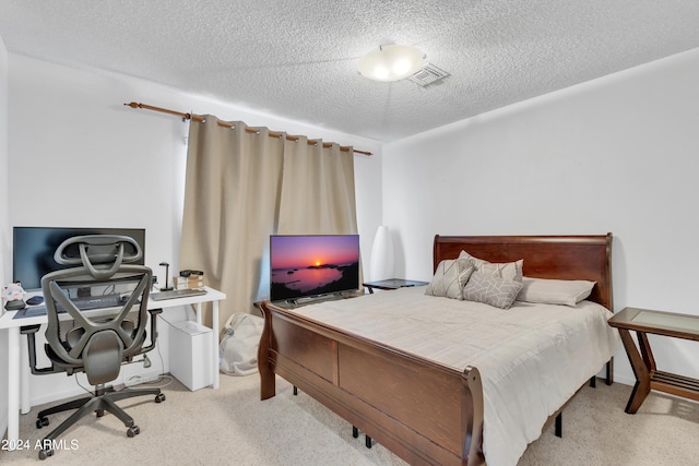 bedroom featuring light colored carpet and a textured ceiling