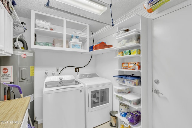 laundry area with electric water heater, washer and clothes dryer, and a textured ceiling