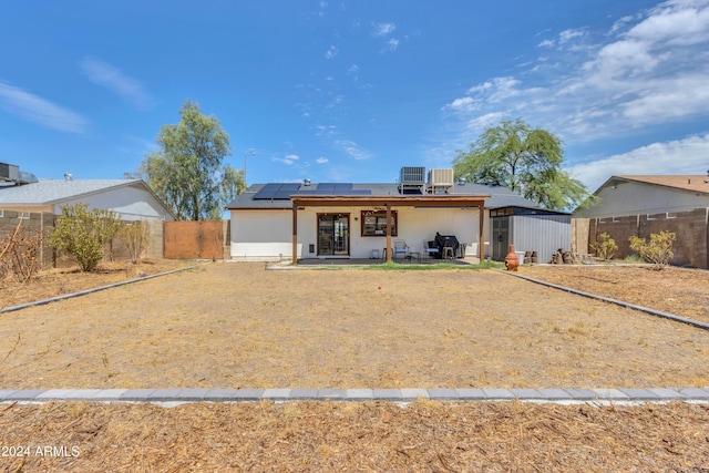 back of house with solar panels and a patio