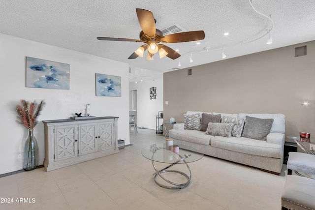 living room featuring ceiling fan and a textured ceiling