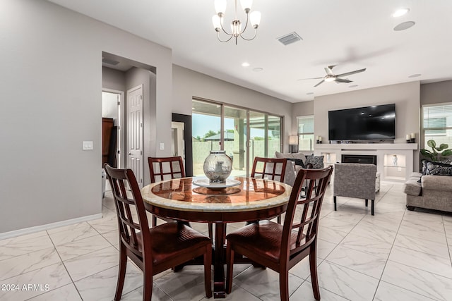 dining room with ceiling fan with notable chandelier and a healthy amount of sunlight