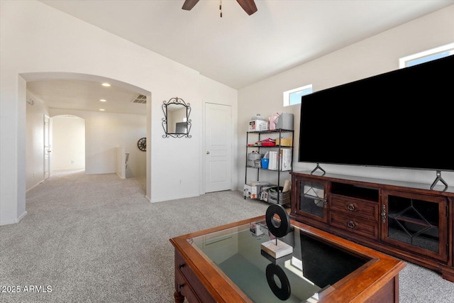 carpeted living room with ceiling fan and vaulted ceiling