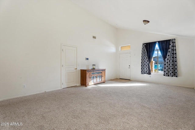 unfurnished living room featuring light colored carpet and high vaulted ceiling