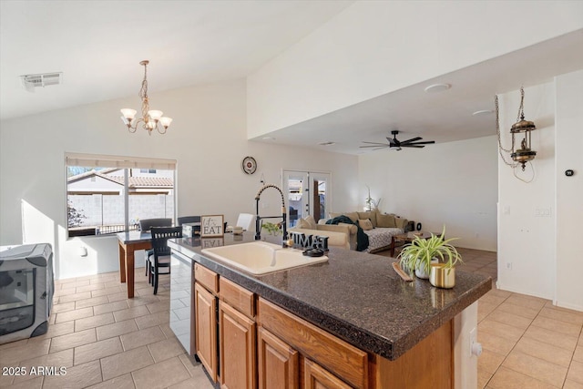 kitchen with light tile patterned flooring, ceiling fan with notable chandelier, a center island with sink, and sink