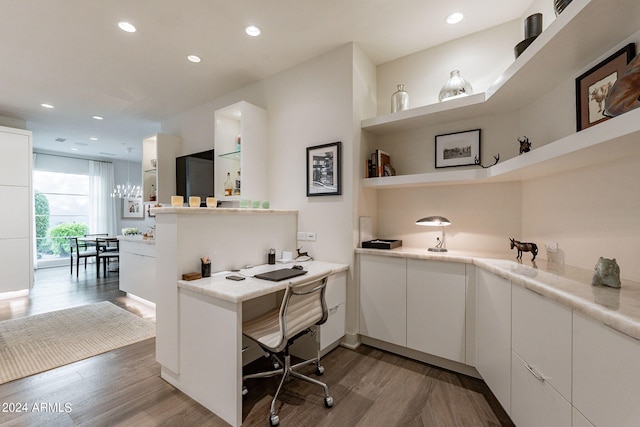 home office featuring hardwood / wood-style flooring and built in shelves