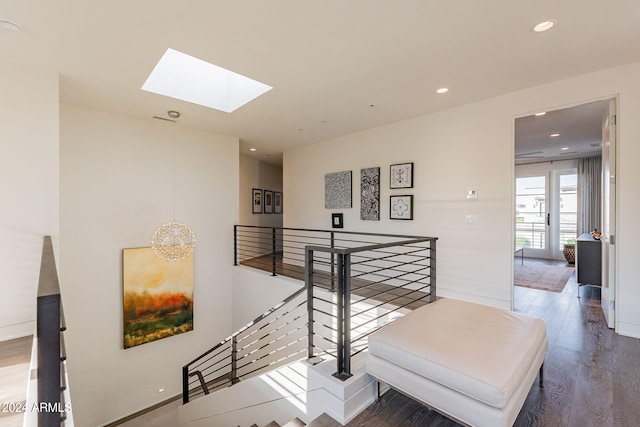 hall featuring wood-type flooring and a skylight