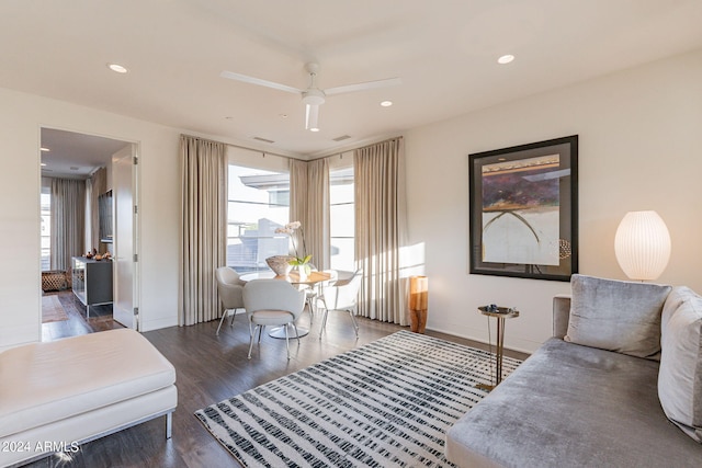 living area with ceiling fan and dark hardwood / wood-style flooring