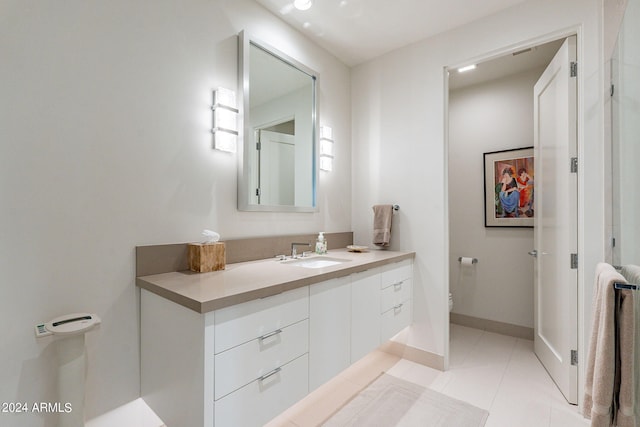 bathroom featuring tile patterned flooring, vanity, and toilet