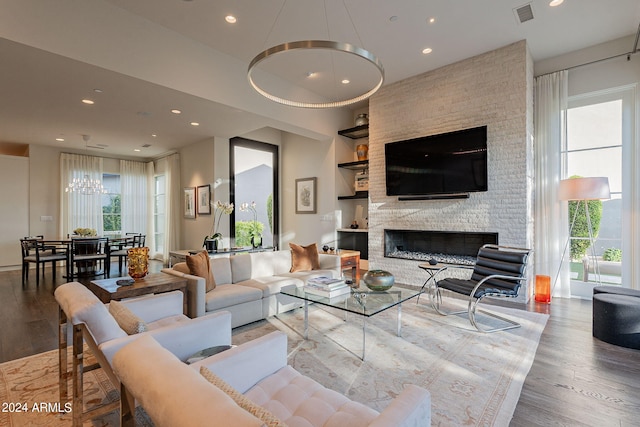 living room with a large fireplace, wood-type flooring, and built in features