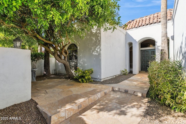 view of exterior entry featuring a patio area