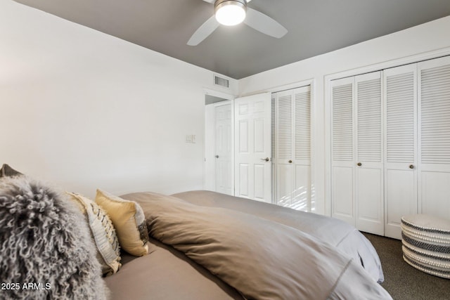 bedroom with ceiling fan and multiple closets