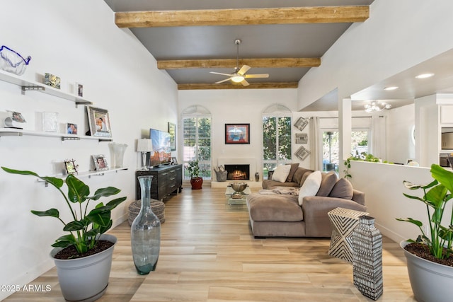 living room featuring beam ceiling, ceiling fan, and light hardwood / wood-style flooring