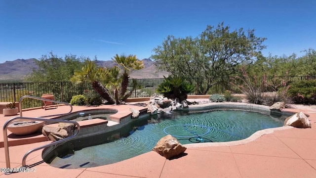 view of pool featuring a fenced in pool, an in ground hot tub, a fenced backyard, and a mountain view