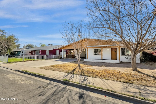 ranch-style house with driveway, fence, and an attached carport