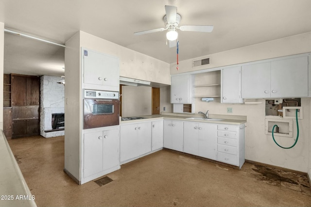 kitchen featuring open shelves, electric cooktop, visible vents, wall oven, and a sink