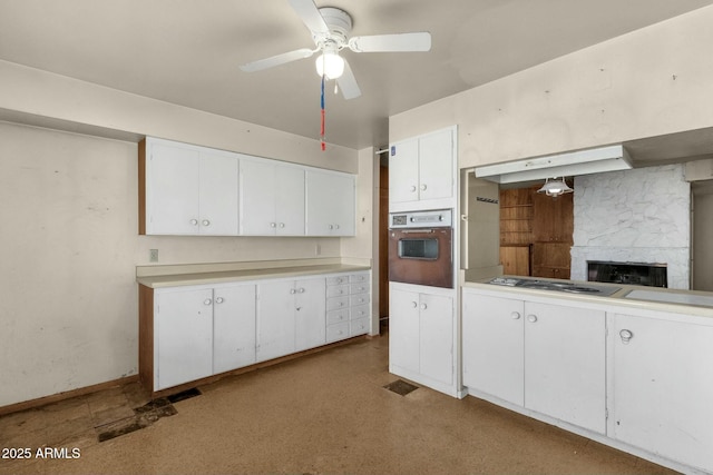 kitchen with white cabinets, ceiling fan, oven, light countertops, and stainless steel electric stovetop