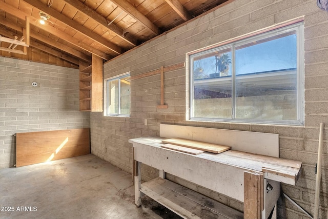 miscellaneous room featuring lofted ceiling with beams, unfinished concrete flooring, and wood ceiling