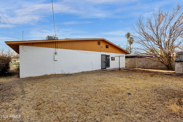 back of property with fence and brick siding