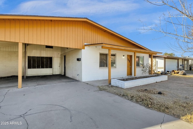 view of front facade with driveway, an attached carport, and brick siding