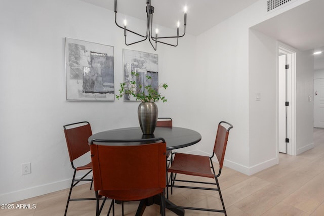 dining area featuring a chandelier and light hardwood / wood-style flooring