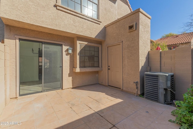 entrance to property with cooling unit and a patio