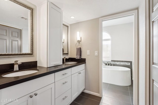 bathroom with tile patterned flooring, vanity, and a bathing tub