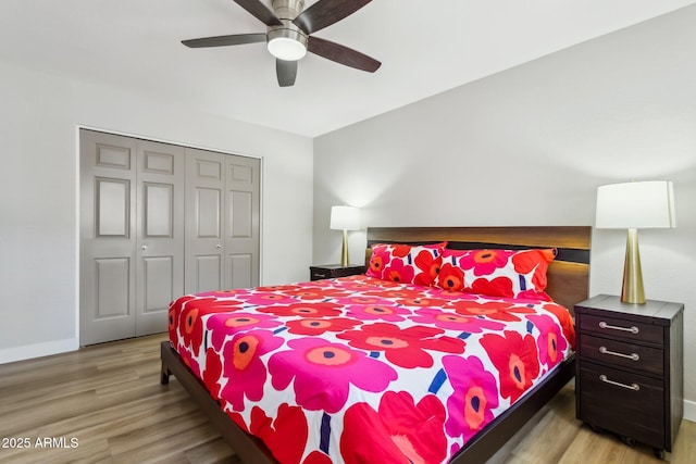 bedroom with a closet, light hardwood / wood-style flooring, and ceiling fan