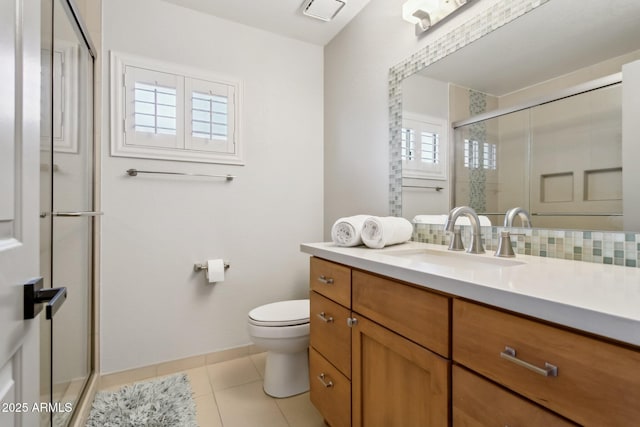 bathroom with tile patterned floors, toilet, decorative backsplash, a shower with door, and vanity