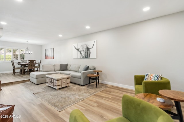 living room with a chandelier and light hardwood / wood-style flooring