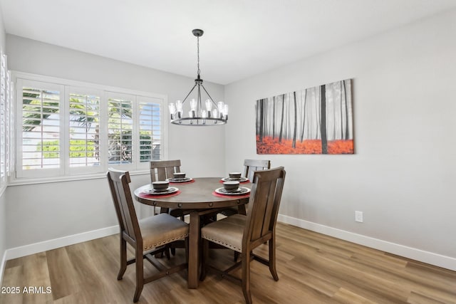 dining area featuring hardwood / wood-style flooring and an inviting chandelier