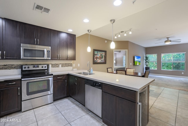 kitchen with ceiling fan, hanging light fixtures, sink, kitchen peninsula, and appliances with stainless steel finishes