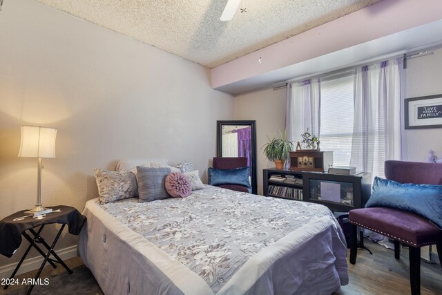 bedroom with wood-type flooring, a textured ceiling, and ceiling fan