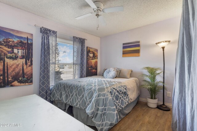 bedroom featuring wood-type flooring, a textured ceiling, and ceiling fan