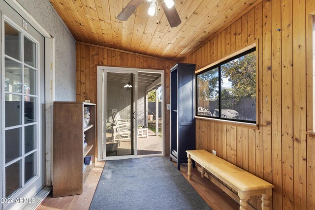 interior space featuring wood walls, vaulted ceiling, ceiling fan, wood-type flooring, and wood ceiling