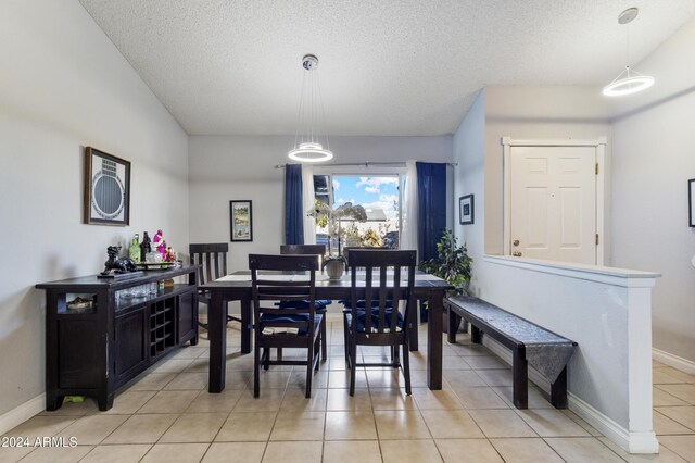 tiled dining area featuring a textured ceiling