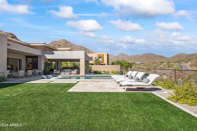 exterior space with a mountain view, a lawn, and a patio area