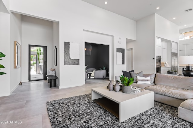 tiled living room with a towering ceiling and plenty of natural light