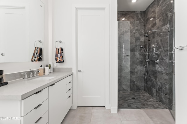 bathroom featuring vanity, tiled shower, and tile patterned flooring