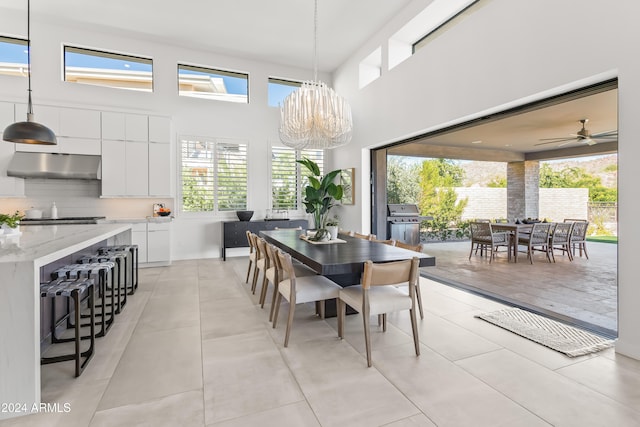 dining space featuring a wealth of natural light, a high ceiling, and light tile patterned floors