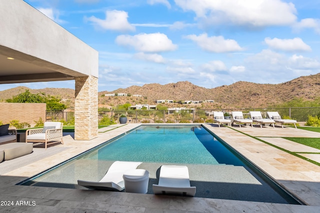 view of swimming pool with a mountain view and a patio area